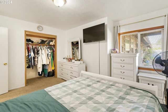 carpeted bedroom with a textured ceiling and a closet