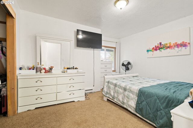 bedroom featuring a textured ceiling, a closet, and carpet flooring