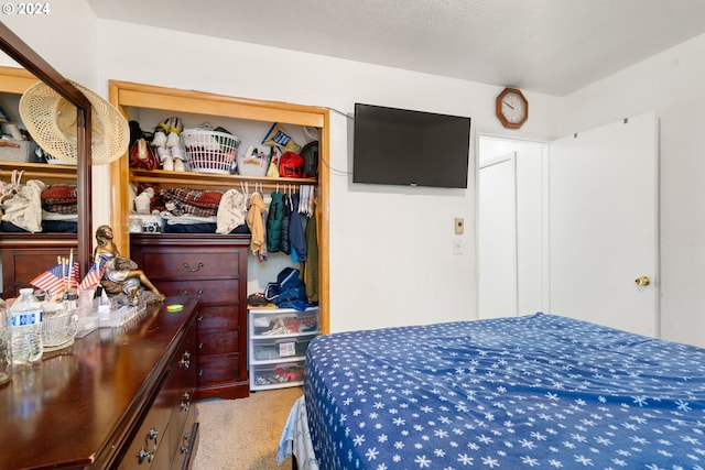 bedroom with light carpet and a closet