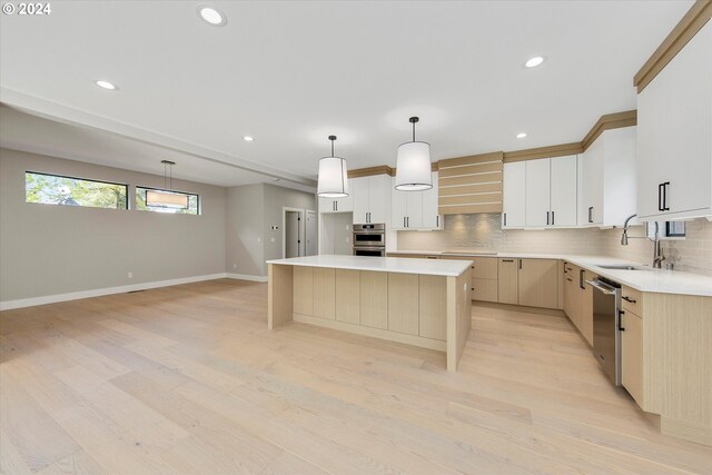 kitchen featuring a kitchen island, tasteful backsplash, sink, custom exhaust hood, and hanging light fixtures