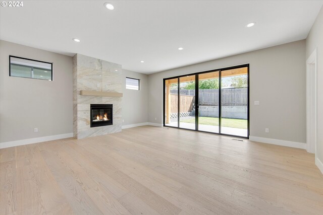 unfurnished living room with a fireplace and light hardwood / wood-style floors