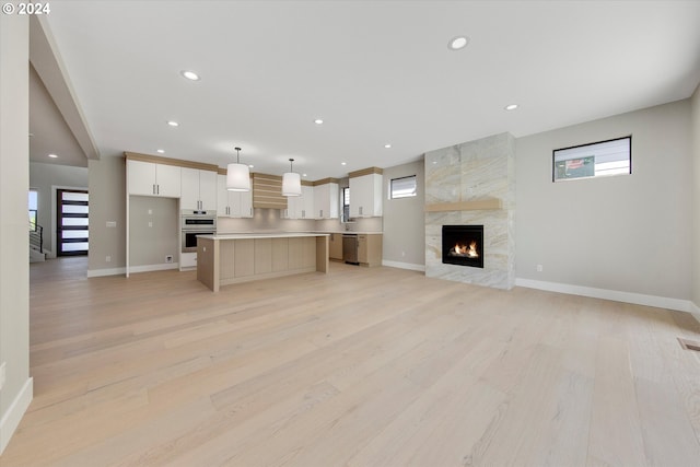 unfurnished living room featuring a fireplace and light hardwood / wood-style floors