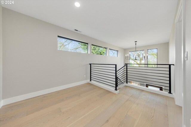 empty room featuring hardwood / wood-style flooring and a notable chandelier