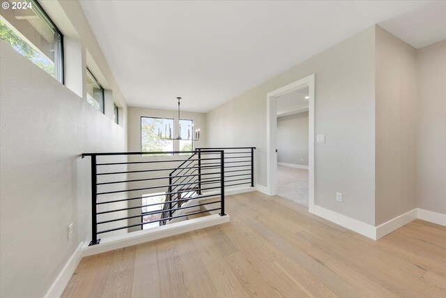 hall with light hardwood / wood-style flooring and a chandelier