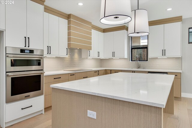 kitchen with sink, white cabinetry, decorative light fixtures, a center island, and black electric stovetop