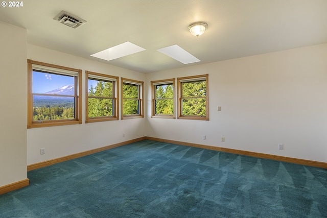 carpeted spare room featuring a skylight