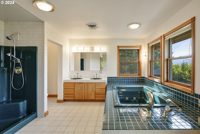 bathroom featuring independent shower and bath, vanity, and tile patterned flooring