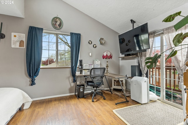 office space with lofted ceiling, a textured ceiling, and hardwood / wood-style floors