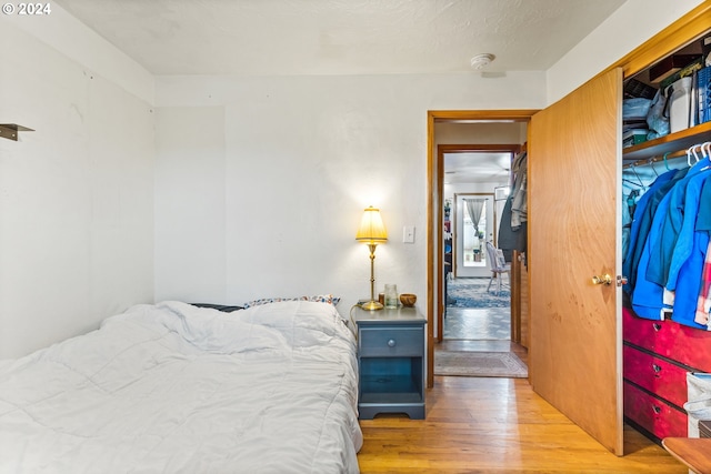 bedroom with light wood-type flooring and a closet