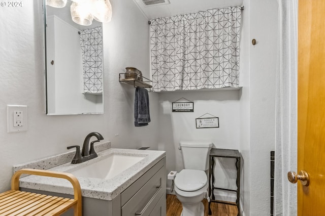 bathroom with vanity, toilet, and hardwood / wood-style flooring