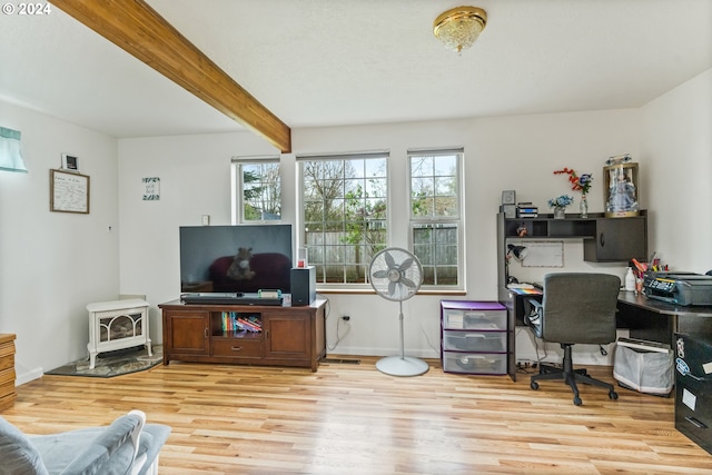 home office with light hardwood / wood-style flooring and beamed ceiling