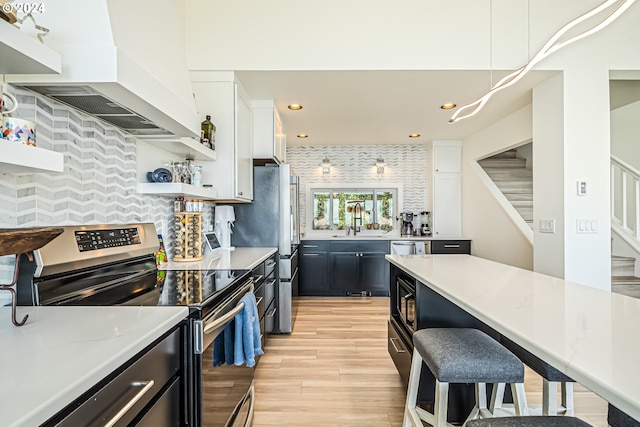 kitchen featuring light stone countertops, stainless steel appliances, custom range hood, and white cabinets