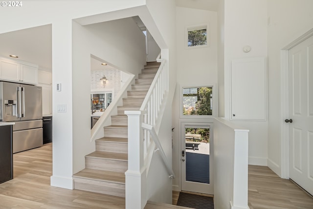 stairs featuring a towering ceiling and hardwood / wood-style flooring