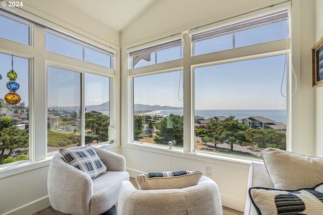 sunroom / solarium with a water view and vaulted ceiling