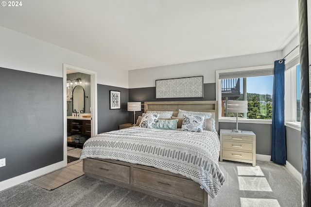 bedroom featuring connected bathroom and light colored carpet