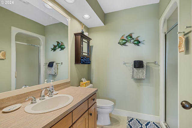 bathroom with tile patterned flooring, vanity, toilet, and a shower with shower door