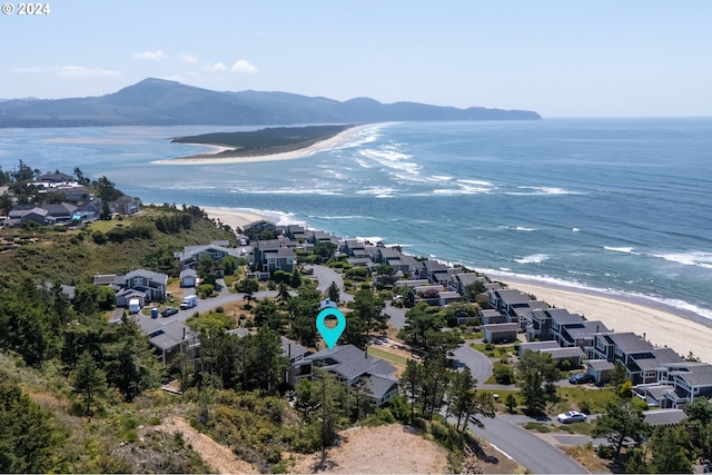 drone / aerial view featuring a view of the beach and a water and mountain view