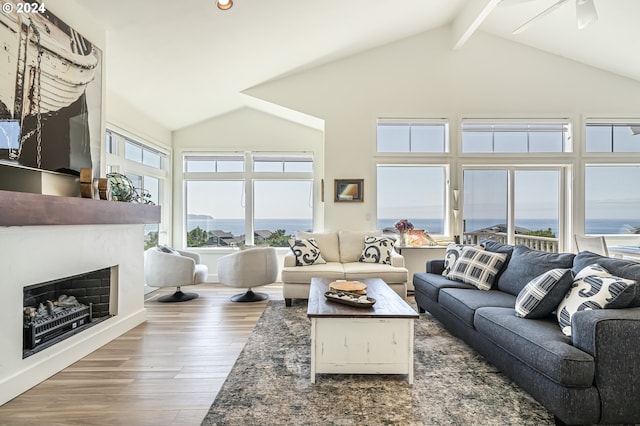 living room featuring hardwood / wood-style floors, high vaulted ceiling, beamed ceiling, and a water view