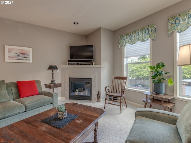 living room featuring carpet flooring, a wealth of natural light, and a tiled fireplace