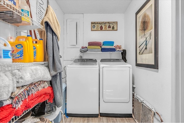 clothes washing area with light hardwood / wood-style floors and washing machine and clothes dryer