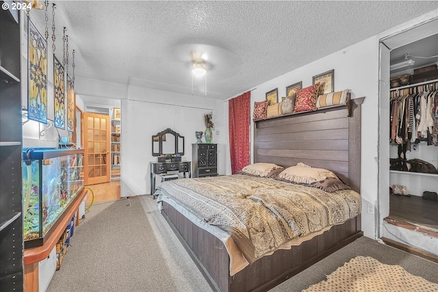 bedroom featuring light carpet, french doors, a textured ceiling, and a closet