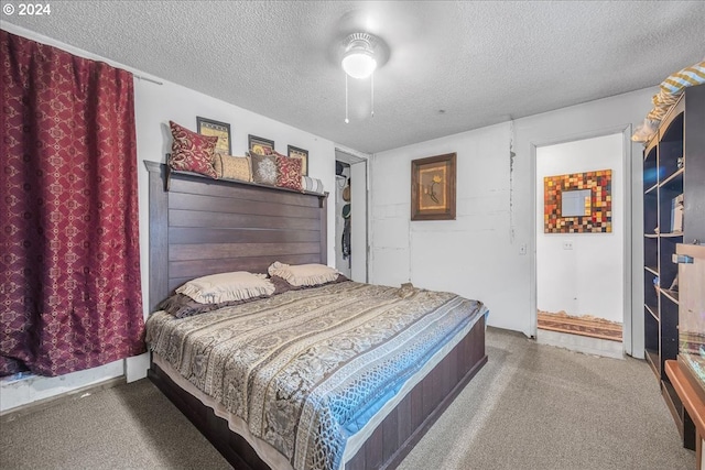 carpeted bedroom featuring ceiling fan and a textured ceiling