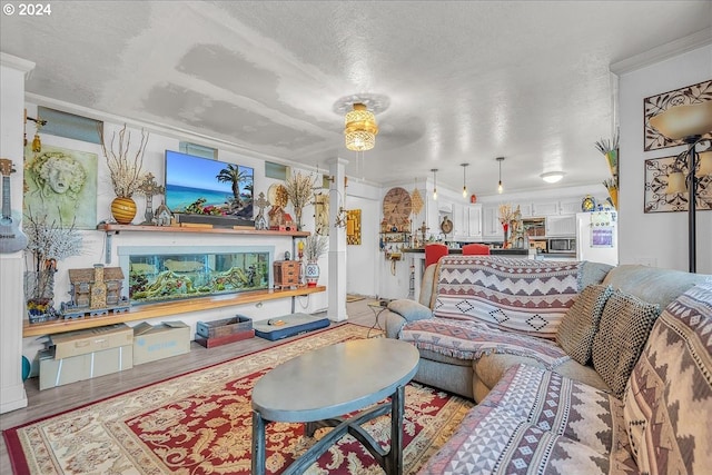 living room with light wood-type flooring, ornamental molding, and a textured ceiling