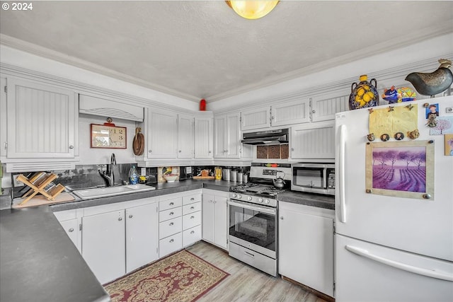 kitchen with sink, stainless steel appliances, light wood-type flooring, and white cabinetry