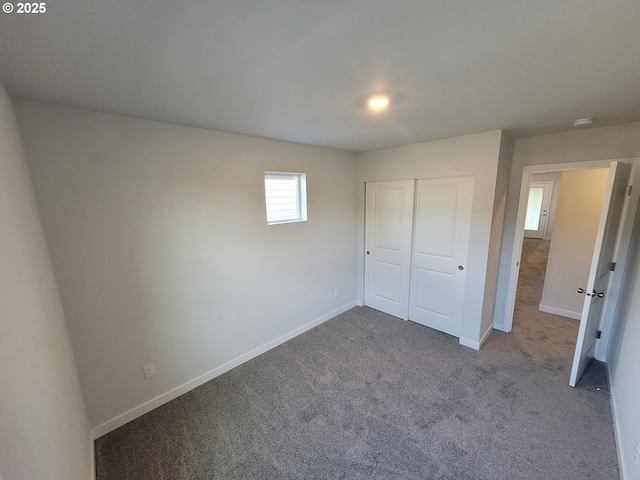 unfurnished bedroom featuring carpet floors, a closet, and baseboards