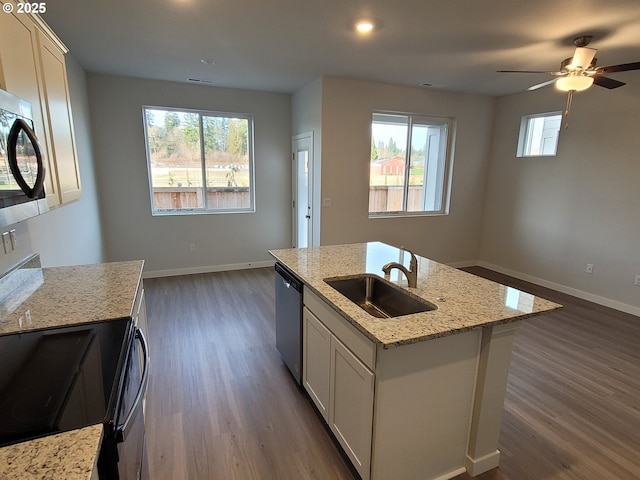 kitchen with a sink, baseboards, light stone countertops, black appliances, and dark wood finished floors