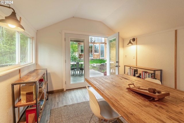 dining area featuring hardwood / wood-style floors and vaulted ceiling