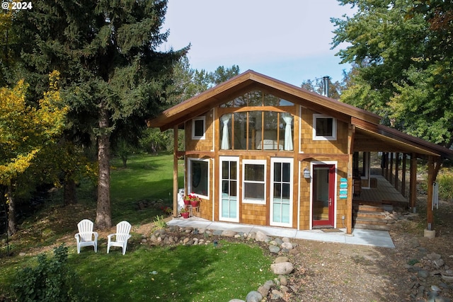 rear view of property featuring a lawn