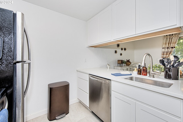 kitchen with stainless steel appliances, sink, and white cabinetry