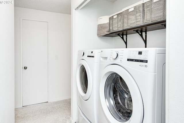 laundry room featuring light colored carpet, a textured ceiling, and washer / dryer