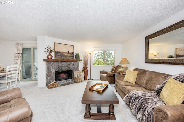 carpeted living room featuring a fireplace and a textured ceiling