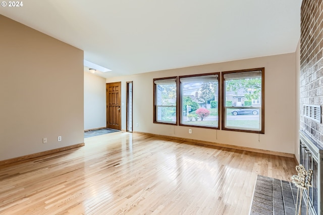 empty room featuring a fireplace and light hardwood / wood-style floors