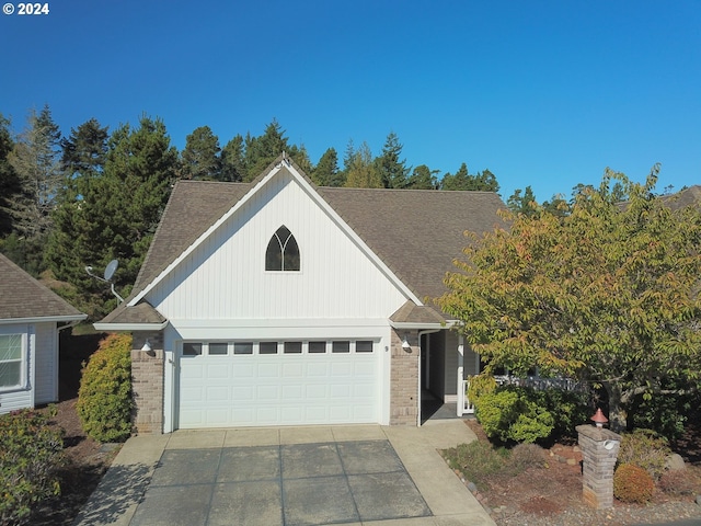 9 Waterford Downs, Florence, OR 97439 - view of front of house featuring a garage, roof with shingles, brick siding, and driveway