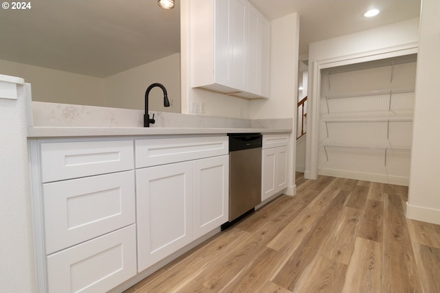 kitchen featuring white cabinets, light wood-type flooring, sink, and stainless steel dishwasher