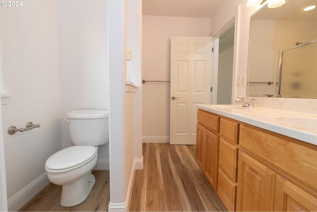 bathroom featuring a shower, hardwood / wood-style floors, vanity, and toilet