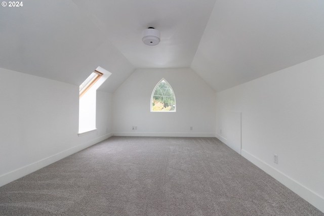 bonus room featuring vaulted ceiling with skylight and carpet