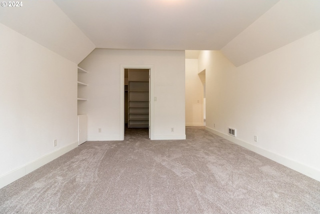 bonus room with carpet floors, lofted ceiling, and built in features