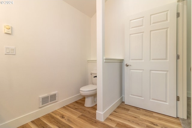 bathroom with hardwood / wood-style floors and toilet