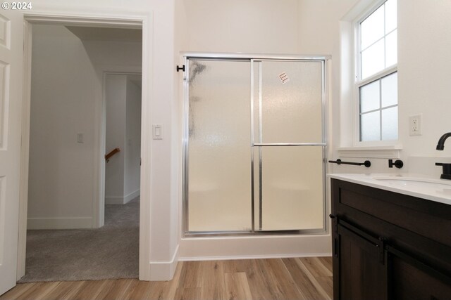 9 Waterford Downs, Florence, OR 97439 - bathroom featuring baseboards, a stall shower, wood finished floors, and vanity