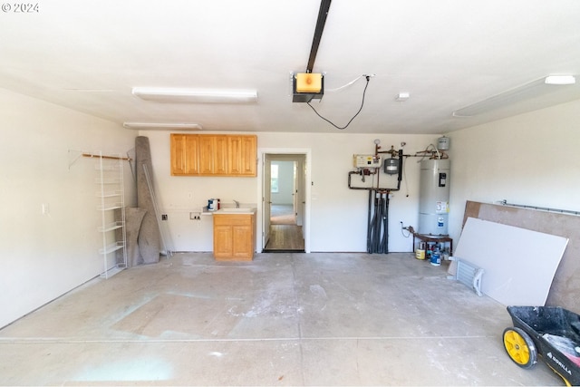 garage featuring a garage door opener, strapped water heater, and sink