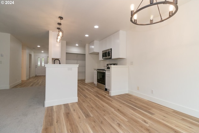 kitchen with stainless steel appliances, light hardwood / wood-style floors, a notable chandelier, white cabinetry, and decorative light fixtures