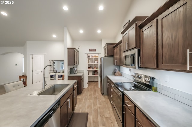 kitchen featuring sink, dark brown cabinets, light hardwood / wood-style flooring, and stainless steel appliances