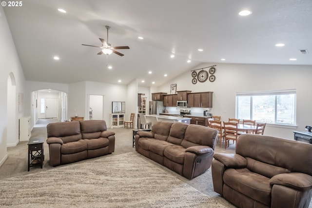 living room featuring high vaulted ceiling, light colored carpet, and ceiling fan