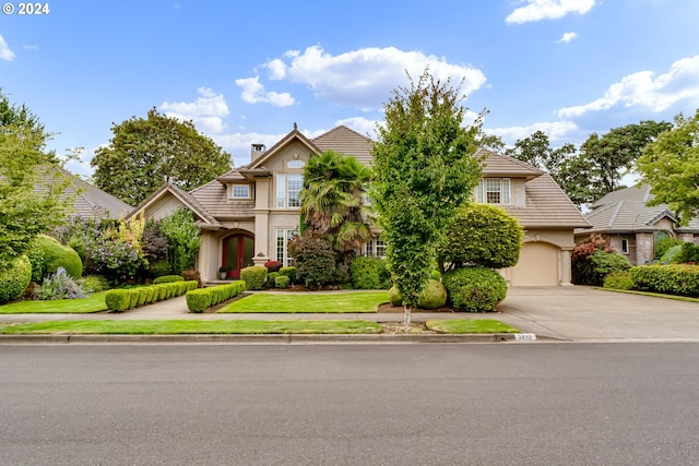 view of front of house featuring concrete driveway, a tiled roof, a front lawn, and stucco siding