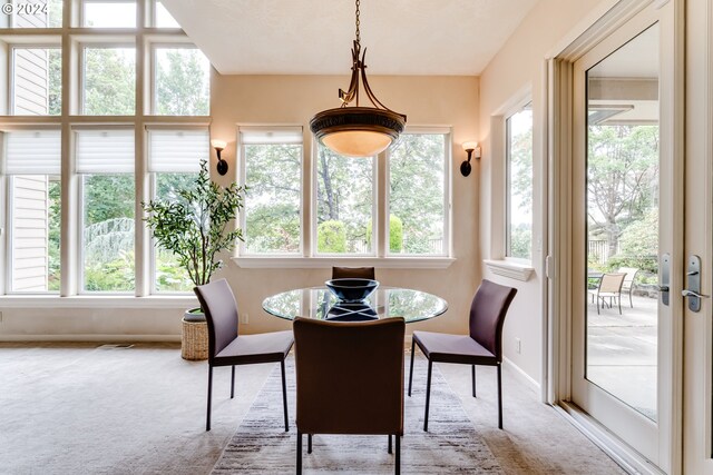 carpeted living room featuring a high ceiling, decorative columns, and a fireplace