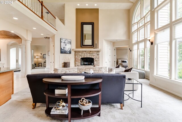 living room with a fireplace, sink, and a towering ceiling